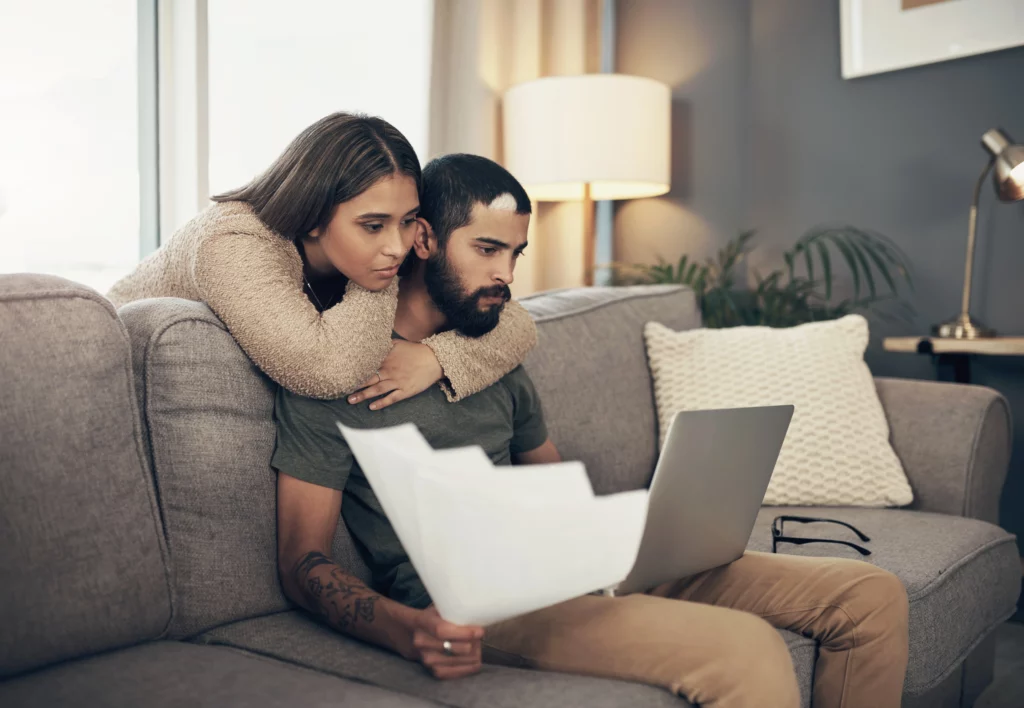 Couple reviewing marriage green card and work authorization documents together on a laptop at home