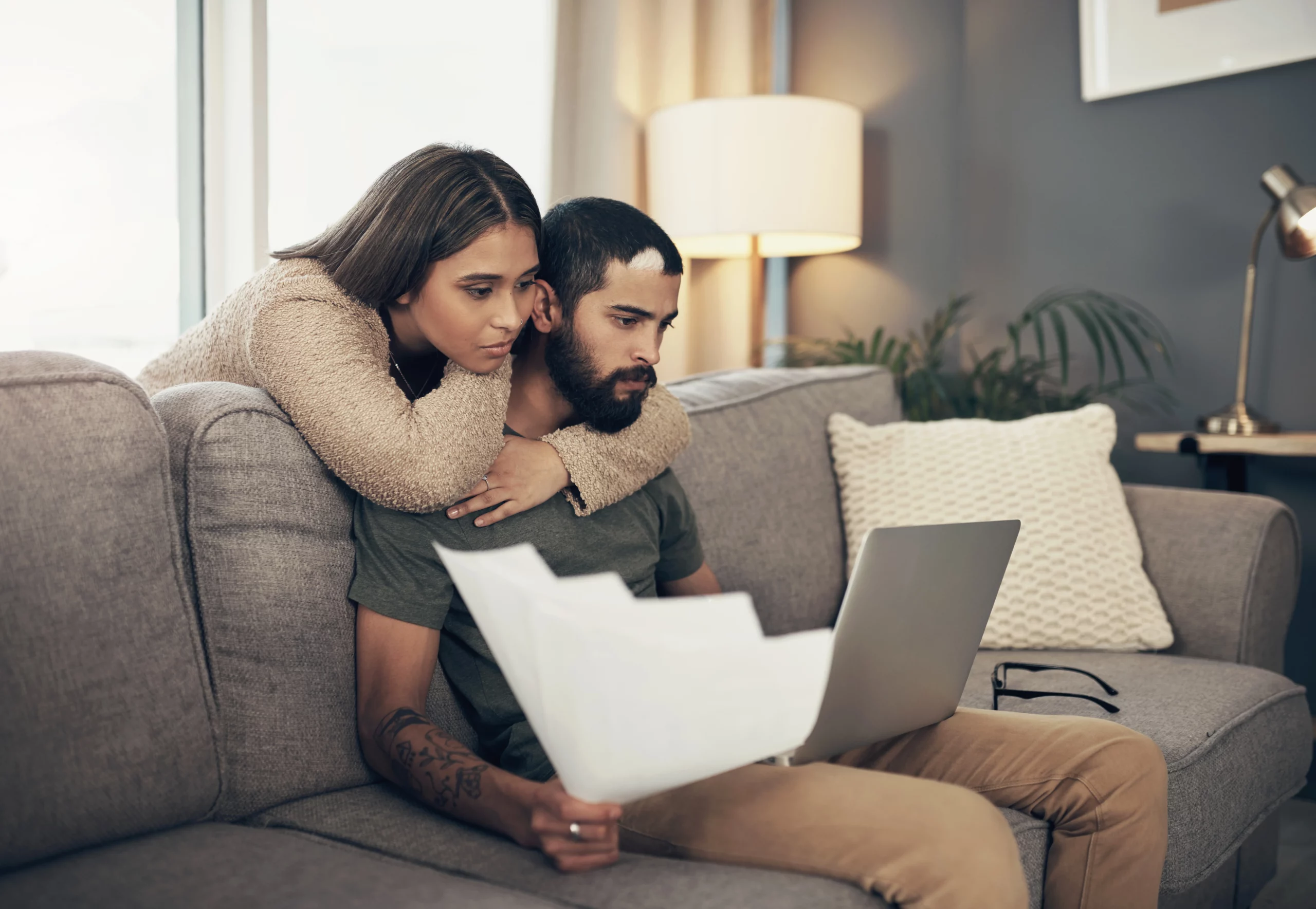 Couple reviewing marriage green card and work authorization documents together on a laptop at home