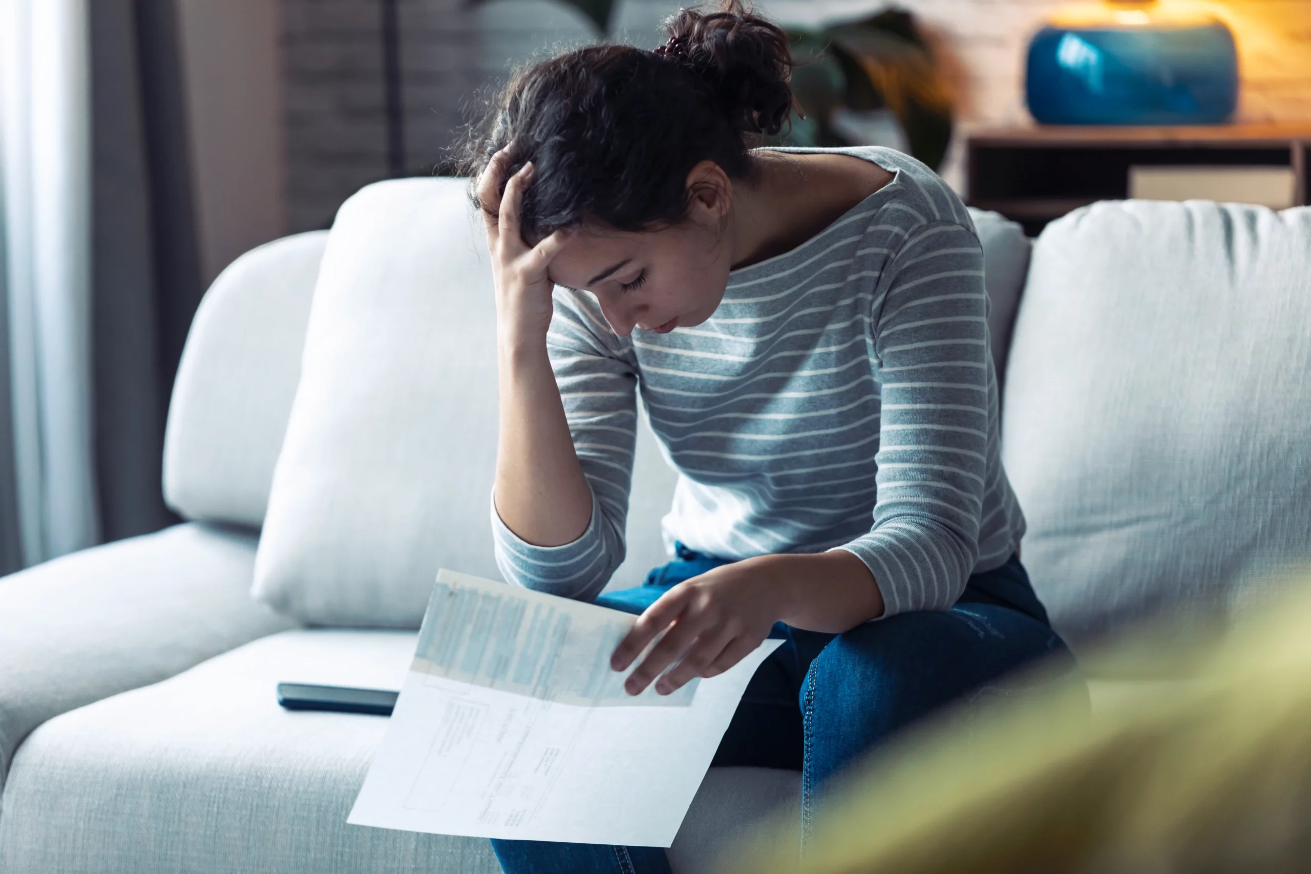 Worried woman holding immigration documents after receiving a USCIS denial letter